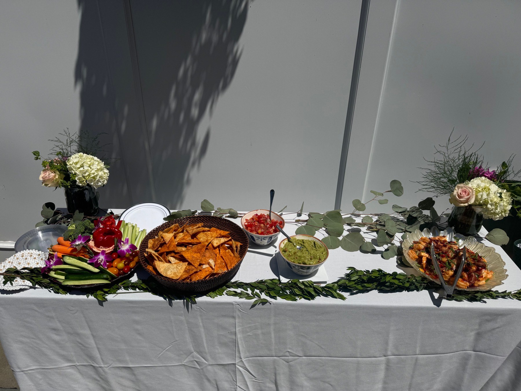 Cocktail table with chips, dips, vegetables, and shrimp