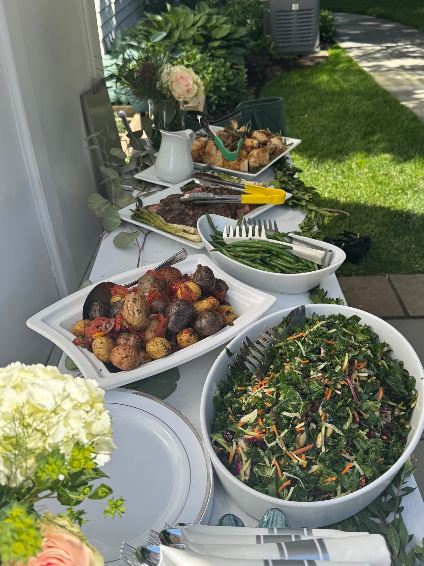 Outdoor event buffet with salads, vegetables, and carved meats